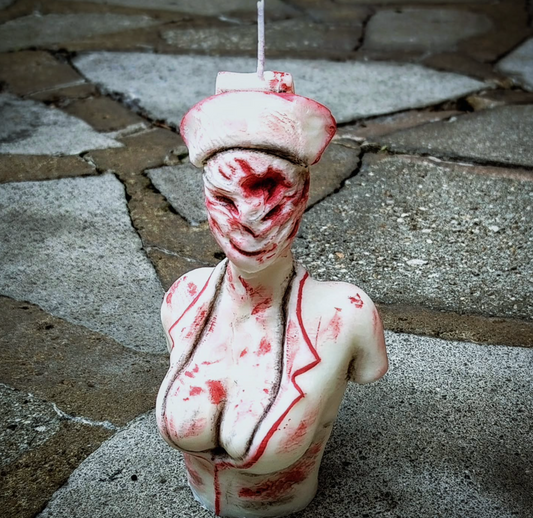 Bust sculpture with red markings on a stone pavement